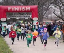 A group of children racing in a 5k fun run.
