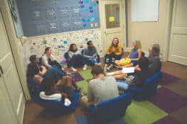 A group of people gathered in a circle talking and listening to one another