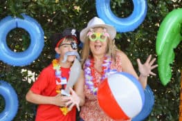 A mother and son pose with silly props