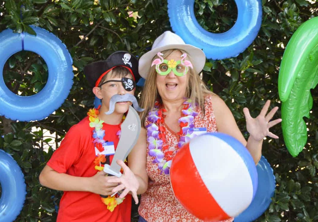 A mother and son pose with silly props