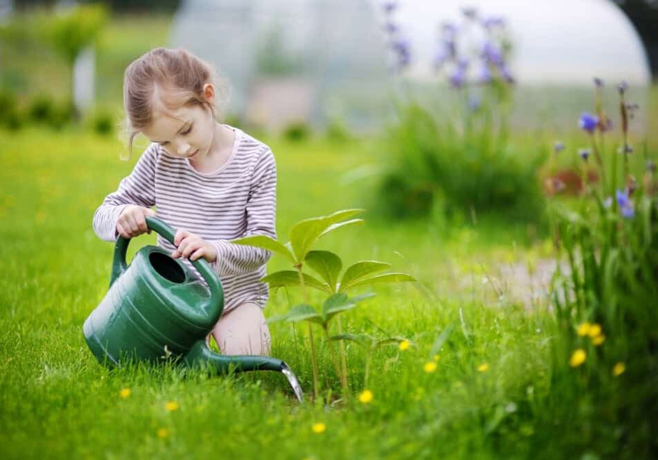 Cute,Little,Girl,Watering,Plants,In,The,Garden