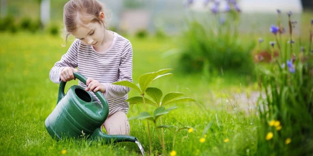 Cute,Little,Girl,Watering,Plants,In,The,Garden